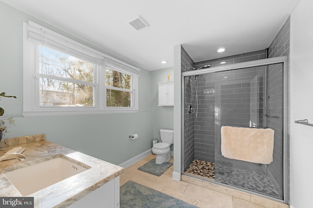 bathroom featuring vanity, a shower with shower door, tile patterned floors, and toilet