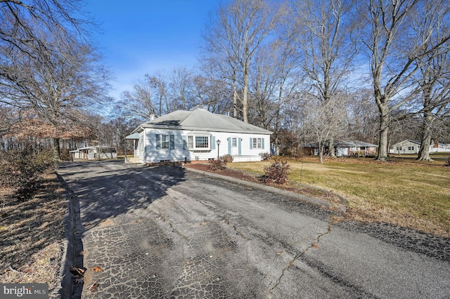 single story home featuring a front lawn and a carport