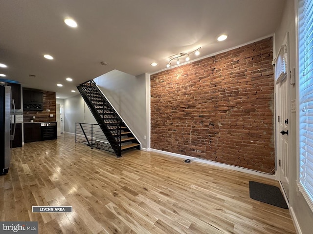 interior space featuring light hardwood / wood-style floors and brick wall