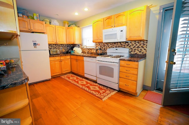 kitchen with light wood-type flooring, light brown cabinetry, and white appliances