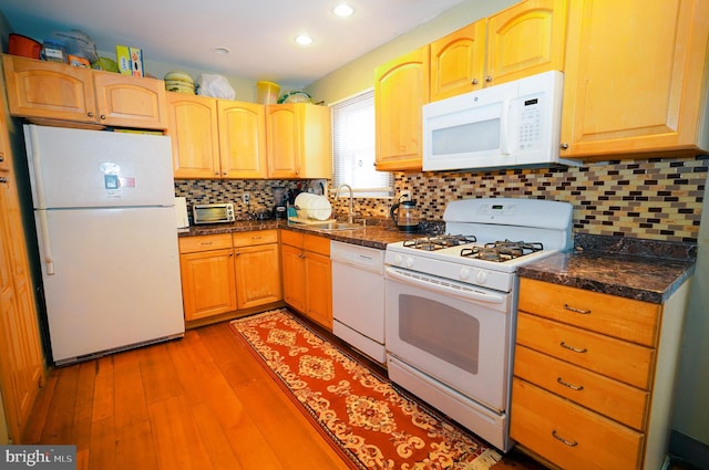 kitchen featuring light wood-type flooring, white appliances, sink, and tasteful backsplash