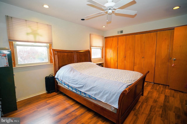 bedroom featuring ceiling fan, dark hardwood / wood-style flooring, and a closet