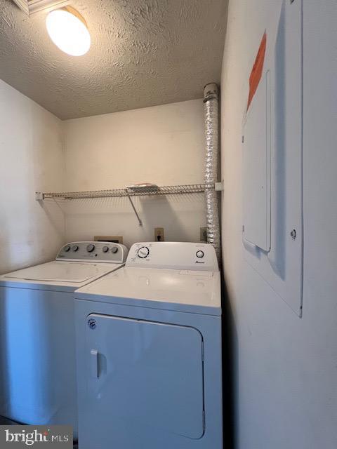 laundry room with washer and dryer and a textured ceiling