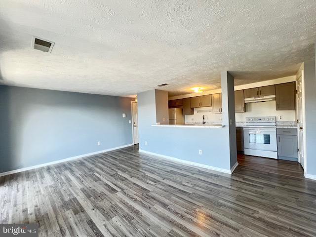 unfurnished living room with dark hardwood / wood-style floors and a textured ceiling