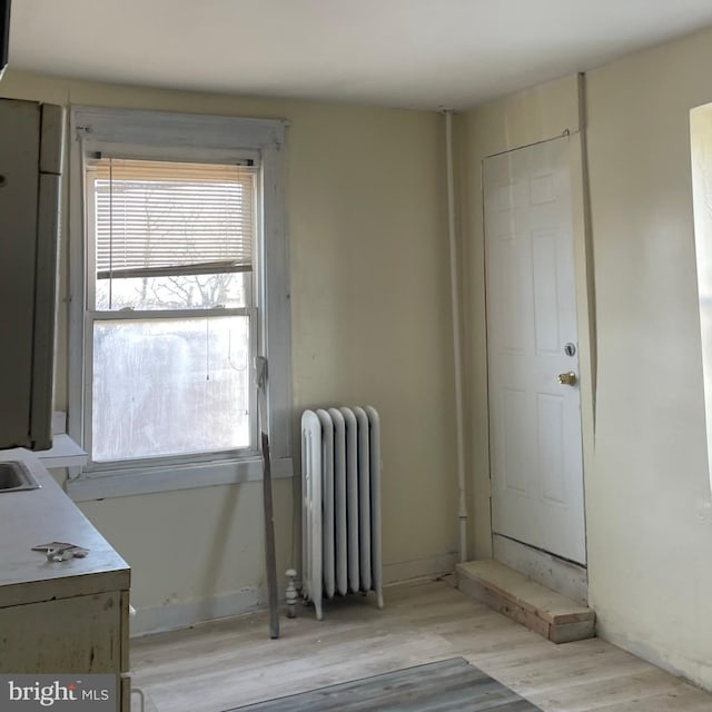 interior space with radiator and light hardwood / wood-style flooring