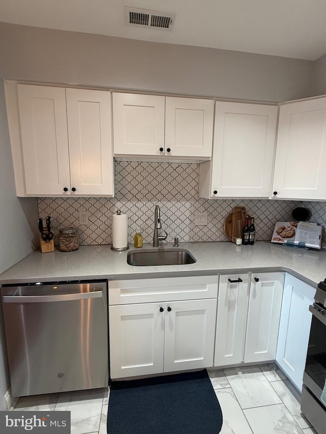 kitchen featuring white cabinets, decorative backsplash, sink, and appliances with stainless steel finishes