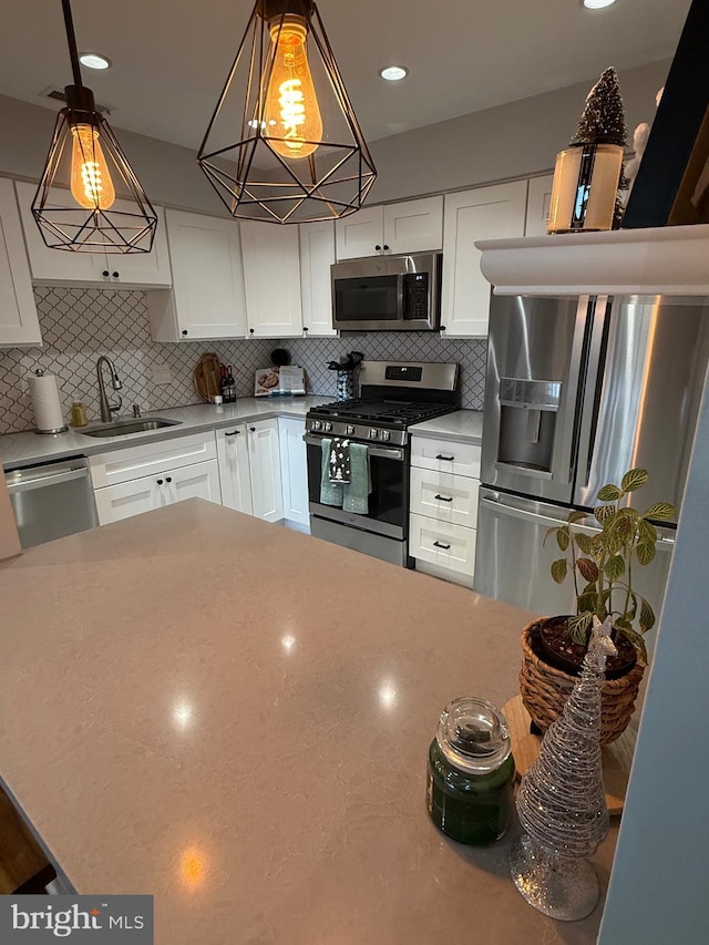 kitchen featuring white cabinets, sink, appliances with stainless steel finishes, and tasteful backsplash