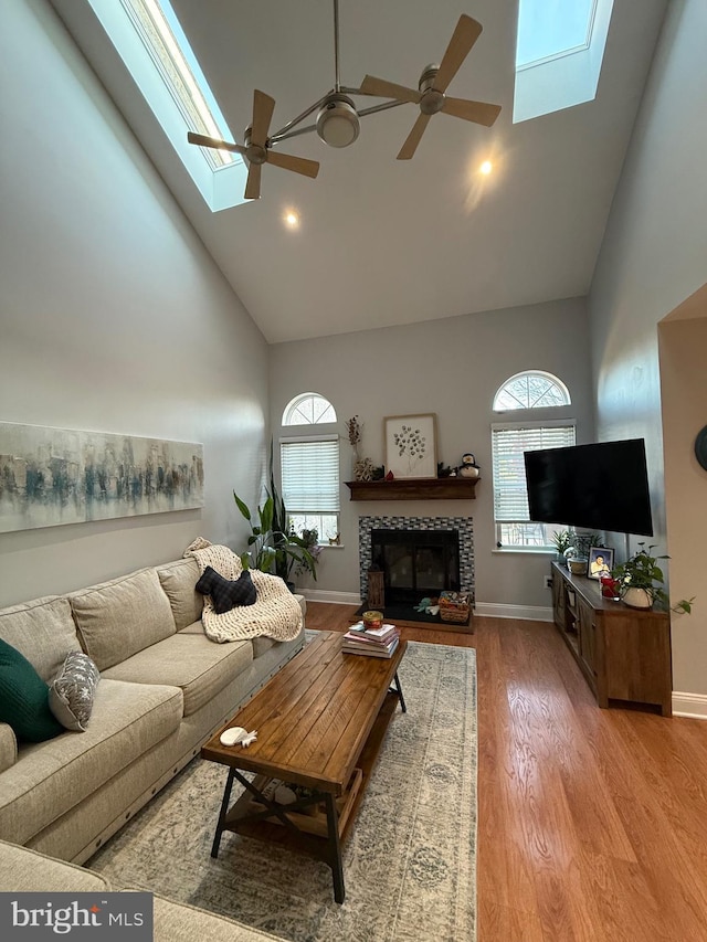 living room with a fireplace, a wealth of natural light, and a skylight