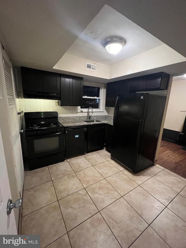 kitchen with light stone countertops, sink, decorative backsplash, light tile patterned floors, and black appliances