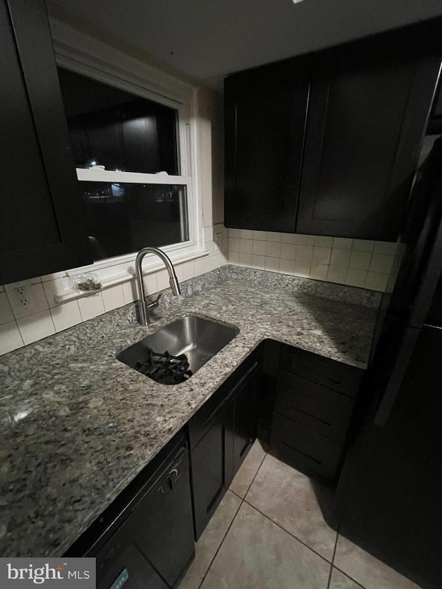 kitchen featuring sink, light tile patterned floors, stone countertops, and black dishwasher