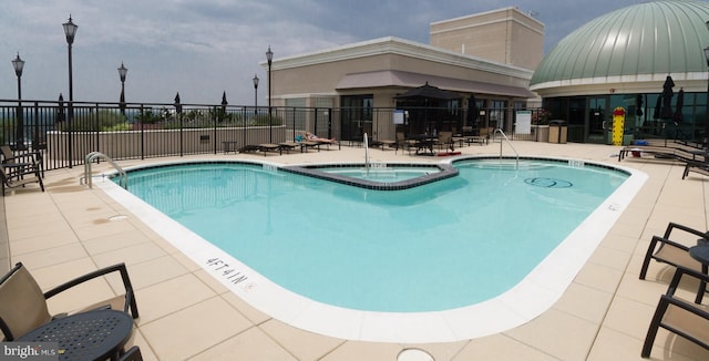 view of swimming pool with a hot tub and a patio area