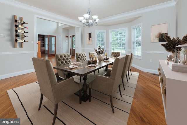 dining room featuring light wood-type flooring, an inviting chandelier, and ornamental molding