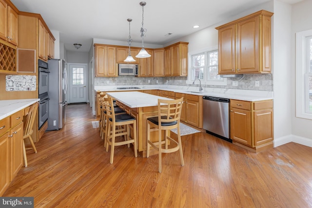 kitchen featuring a center island, stainless steel appliances, a healthy amount of sunlight, and sink