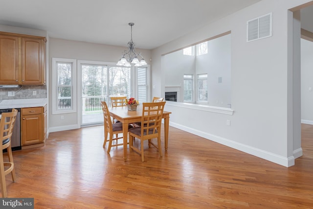 dining room with light hardwood / wood-style floors and a notable chandelier