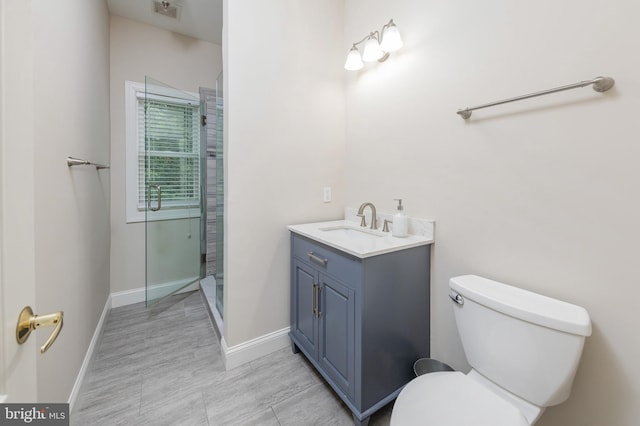 bathroom with an enclosed shower, vanity, and toilet