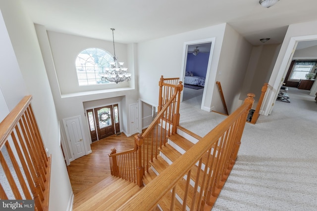 entryway with a notable chandelier and light carpet