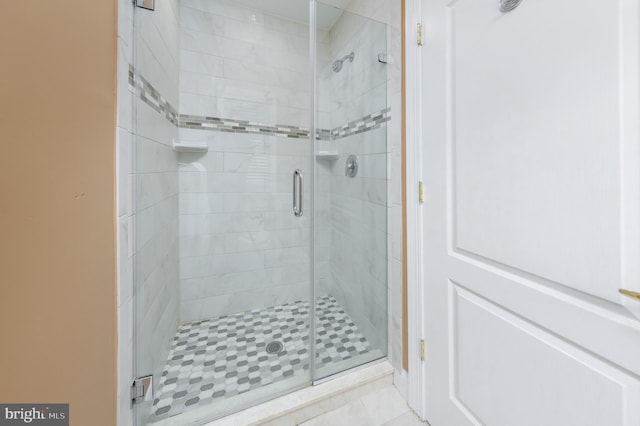 bathroom with a shower with door and tile patterned flooring