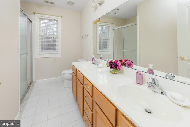 bathroom featuring tile patterned floors, vanity, toilet, and a shower with shower door