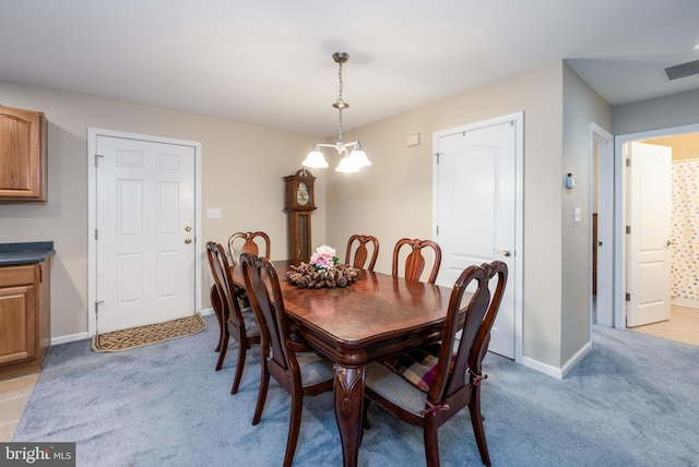 carpeted dining area with a notable chandelier