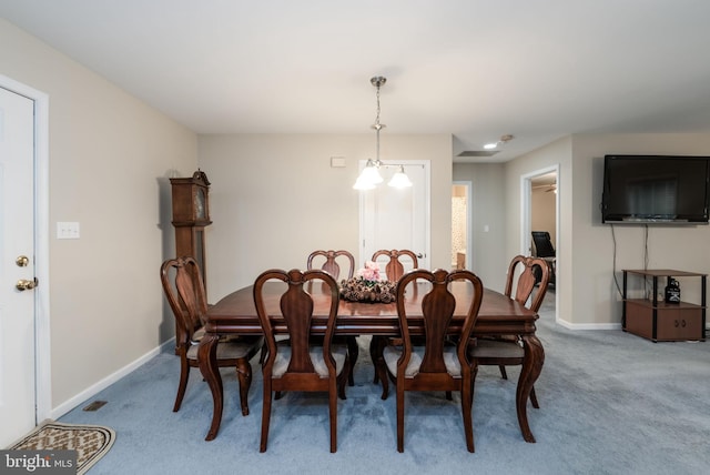 dining space featuring carpet and a notable chandelier