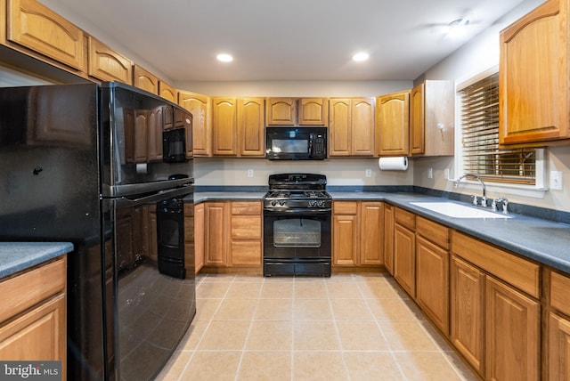 kitchen featuring black appliances, light tile patterned floors, and sink