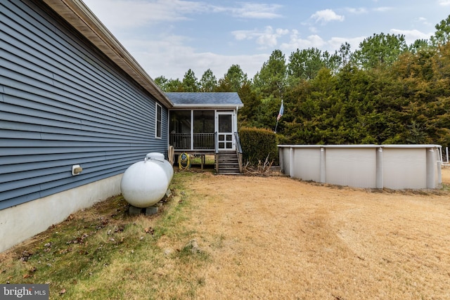 view of yard with a sunroom and a swimming pool