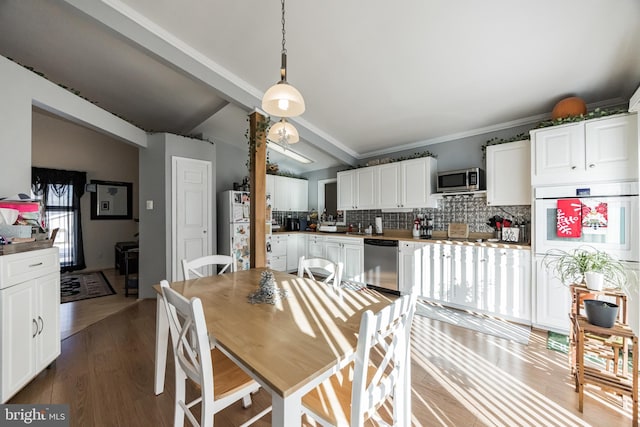 dining area featuring dark hardwood / wood-style flooring and lofted ceiling with beams