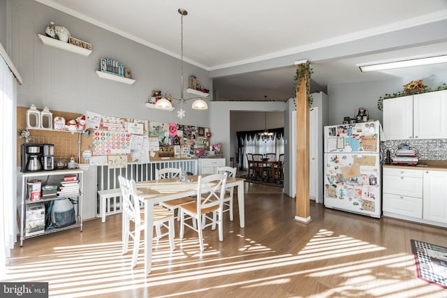 dining area featuring hardwood / wood-style flooring and crown molding