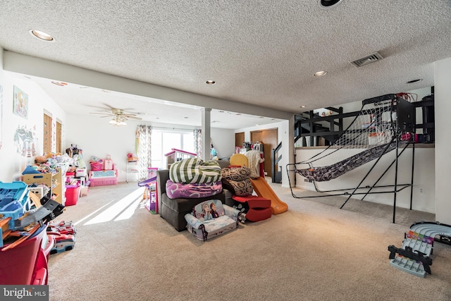 game room with carpet flooring, ceiling fan, and a textured ceiling