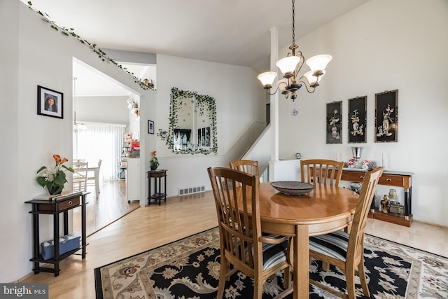 dining room with light hardwood / wood-style floors and an inviting chandelier