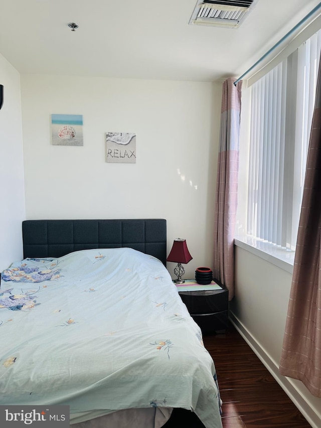 bedroom with dark hardwood / wood-style floors