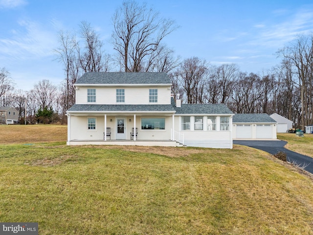 view of front of home featuring an outdoor structure, covered porch, a front yard, and a garage