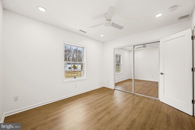 unfurnished bedroom with ceiling fan, wood-type flooring, and a closet