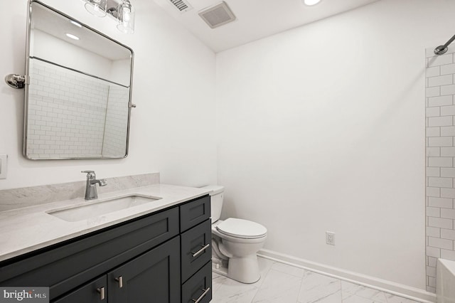 bathroom featuring vanity, toilet, and walk in shower