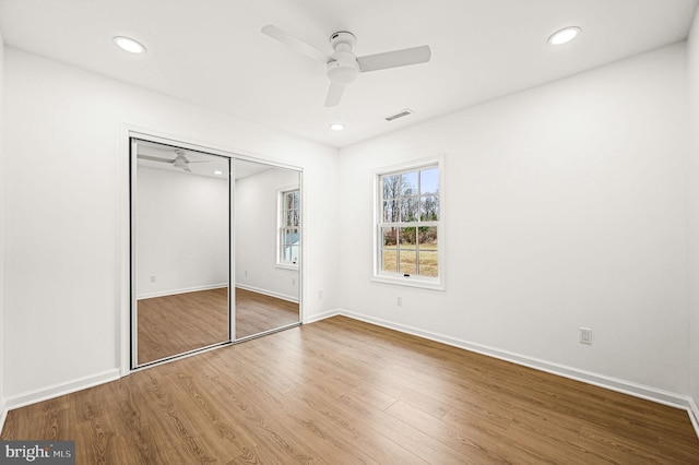 unfurnished bedroom with ceiling fan, wood-type flooring, and a closet