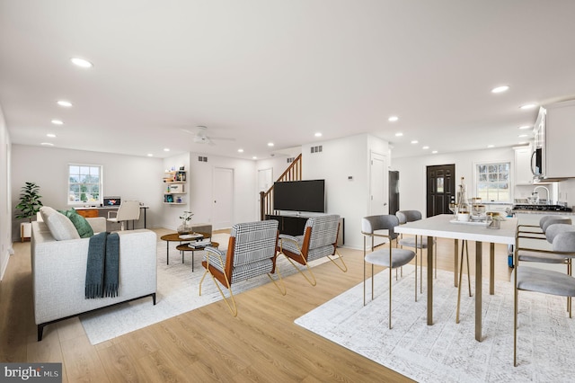 living room with ceiling fan and light hardwood / wood-style flooring