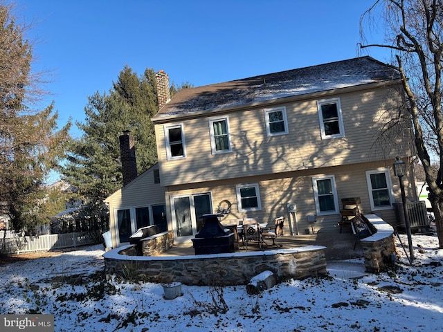 snow covered property featuring a patio