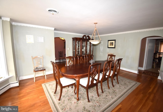 dining area with a baseboard heating unit, hardwood / wood-style flooring, and ornamental molding