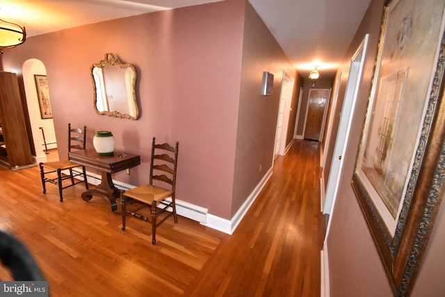 corridor with wood-type flooring and a baseboard radiator