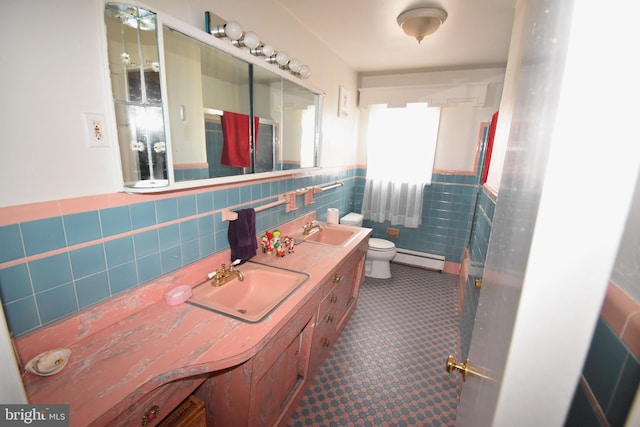 bathroom featuring a baseboard radiator, tile walls, vanity, and toilet