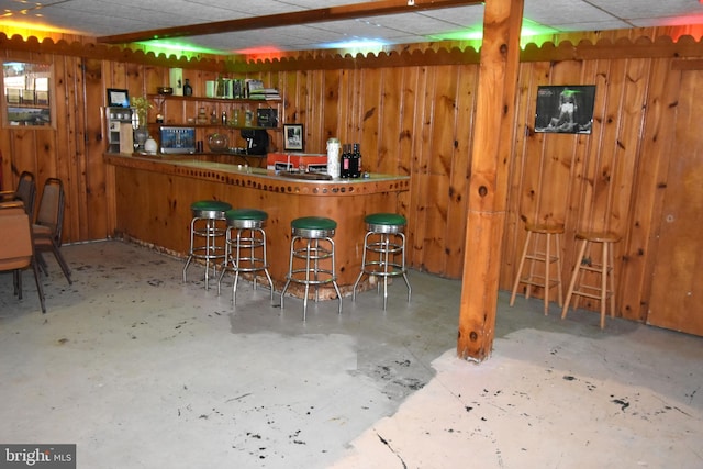 bar with a paneled ceiling and wooden walls