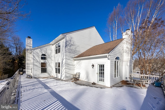 view of snow covered rear of property