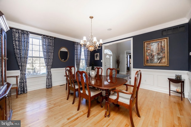 dining room featuring an inviting chandelier, crown molding, and light hardwood / wood-style flooring