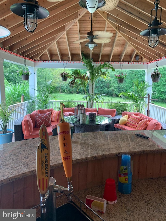 view of patio featuring a gazebo, ceiling fan, and a bar