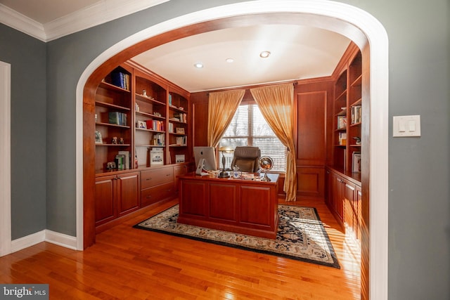 office area with hardwood / wood-style floors, built in features, and ornamental molding