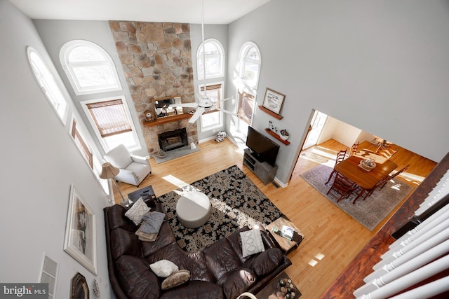 living room with a fireplace, hardwood / wood-style floors, and high vaulted ceiling