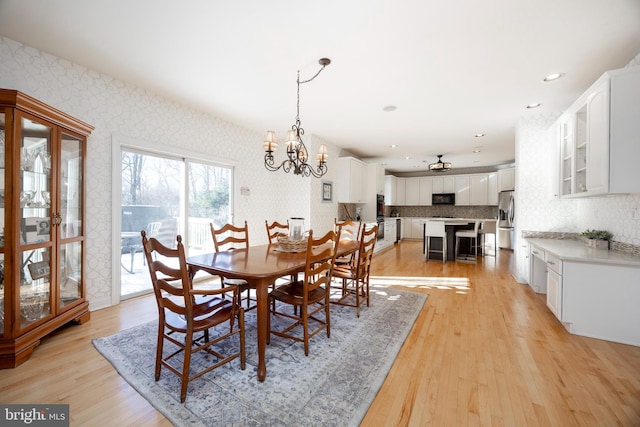 dining room with a notable chandelier and light wood-type flooring