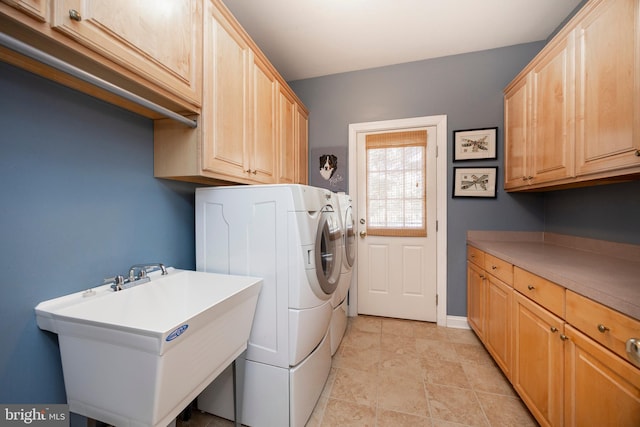 washroom featuring sink, cabinets, and independent washer and dryer