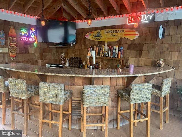 bar featuring hardwood / wood-style floors and beam ceiling