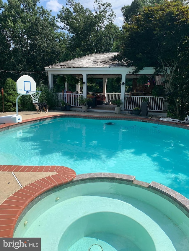 view of pool with an in ground hot tub